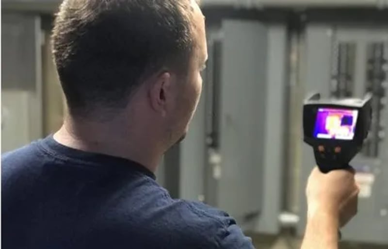 Green Attic Insulation Worker Inspecting with Thermal Imaging Camera